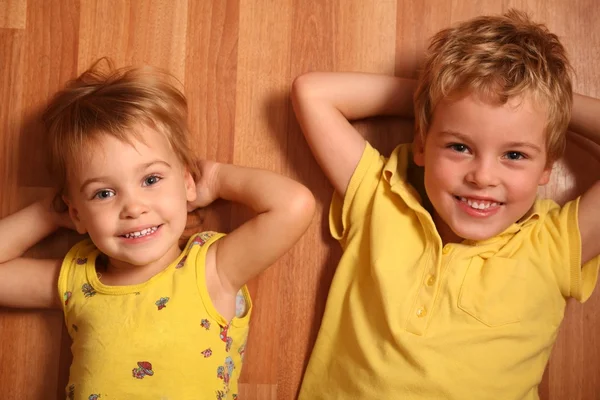 Dos niños yacen en el piso 2 —  Fotos de Stock
