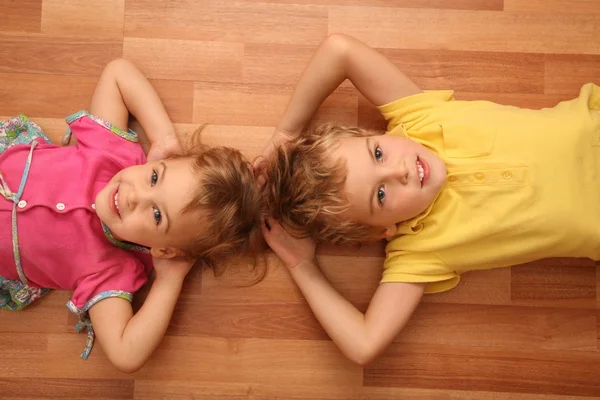 Sister and brother lie on floor — Stock Photo, Image