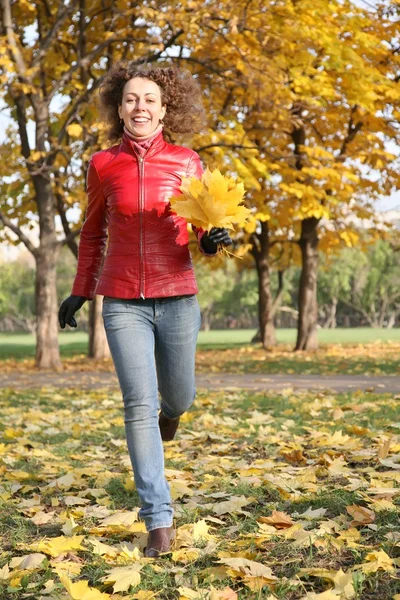 Девушка в красной куртке в парке осенью — стоковое фото