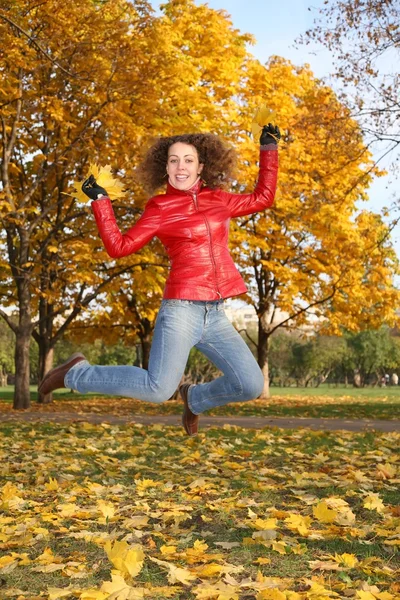 Dívka v červené bundě skoky v parku na podzim 2 — Stock fotografie
