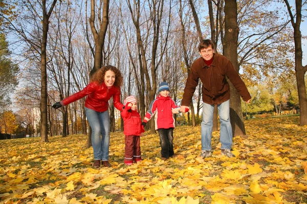Otec a matka s dětmi v parku na podzim — Stock fotografie