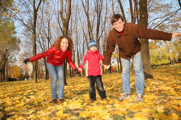 Pai e mãe com o filho no parque no outono — Fotografia de Stock