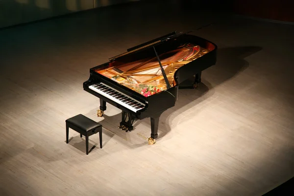 Piano met boeket van bloemen op de scène in concertzaal — Stockfoto