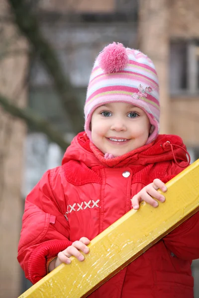 Portret dziewczynki, który odbywa się na sztachety drewniane — Zdjęcie stockowe