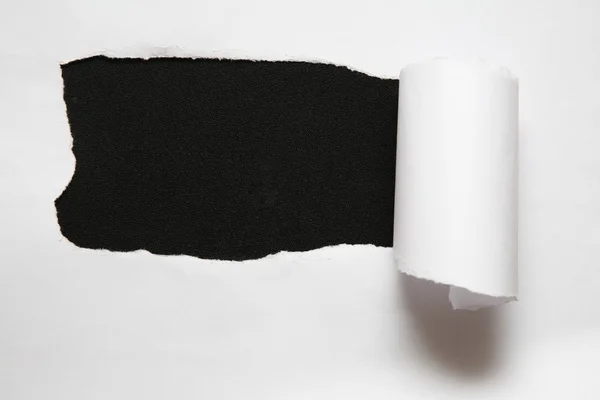 Het blad van gescheurd papier tegen de zwarte achtergrond — Stockfoto