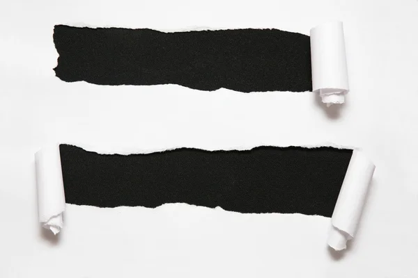 La hoja de papel con dos agujeros sobre el fondo negro —  Fotos de Stock