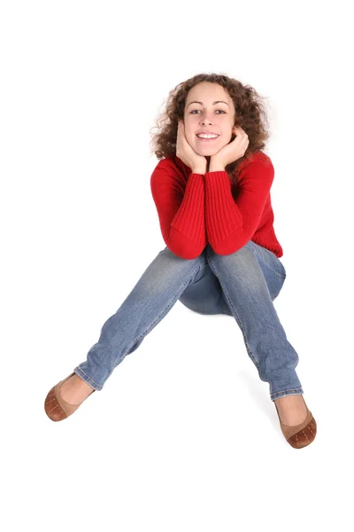 Szczęśliwa dziewczyna kręcone siedzieć. czerwona kurtka, niebieskie dżinsy — Zdjęcie stockowe