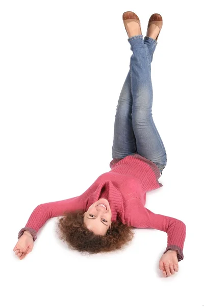 Junge Frau liegt mit den Füßen nach oben auf dem weißen — Stockfoto