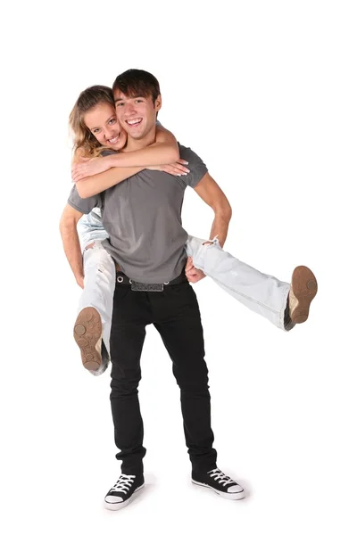 Dívka objímá chlapce zezadu, drží ji na ruce, za nohy na th — Stock fotografie