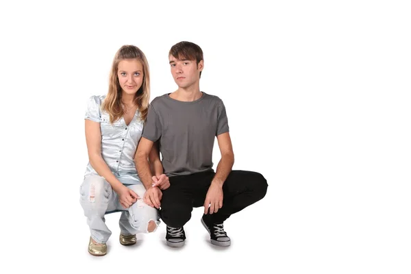 Serious teenager couple sit on white — Stock Photo, Image