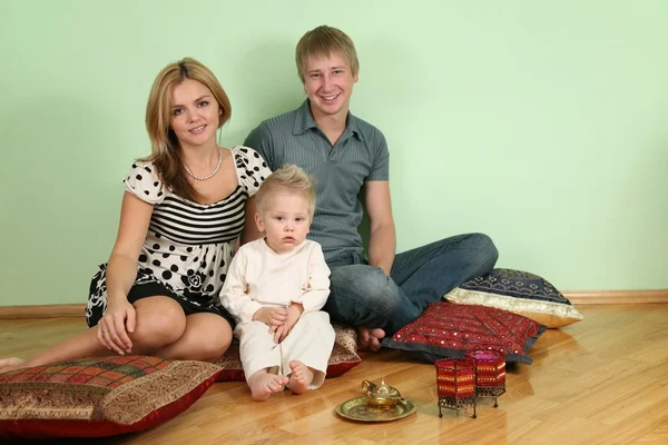 Familjen sitta på golvet på kudde — Stockfoto