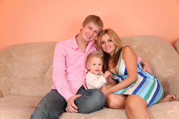 2 핑크 방에 소파에 젊은 가족 — 스톡 사진