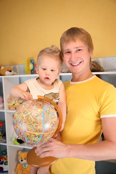 Ojciec trzyma dziecko i kula ziemska w ręce — Zdjęcie stockowe