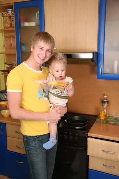 Padre sostiene niño en las manos en la cocina — Foto de Stock