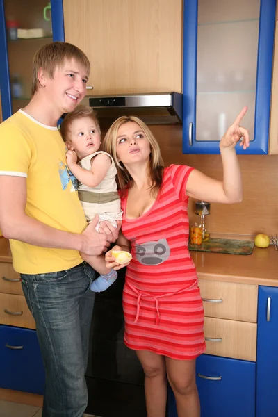 Rodzice i dziecko na ręce w kuchni — Zdjęcie stockowe
