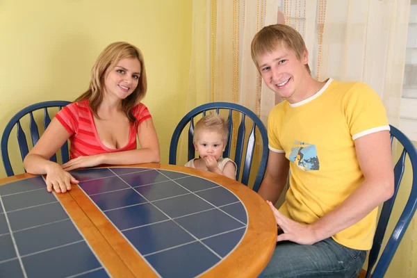 Rodzice z dzieckiem siedzieć przy stole w pokoju — Zdjęcie stockowe