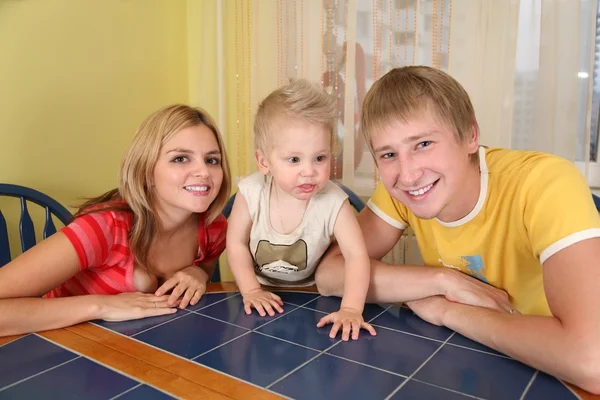 Eltern mit Kind sitzen am Tisch — Stockfoto