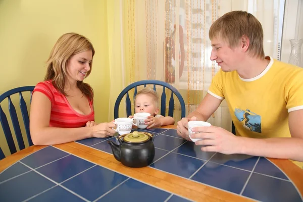Pais com criança bebem chá à mesa no quarto — Fotografia de Stock