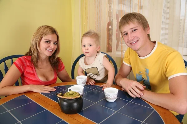 Pais com criança bebem chá à mesa no quarto 2 — Fotografia de Stock