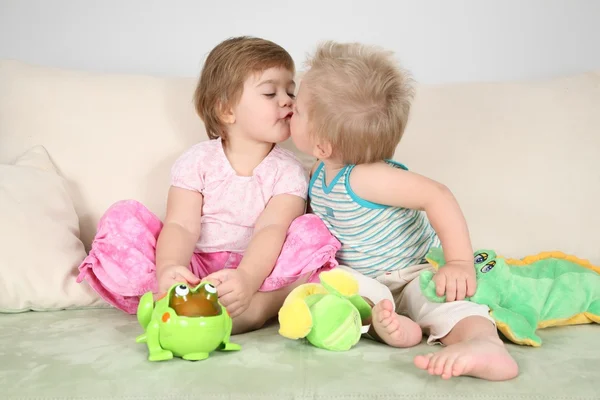 Two children kissing on sofa — Stock Photo, Image