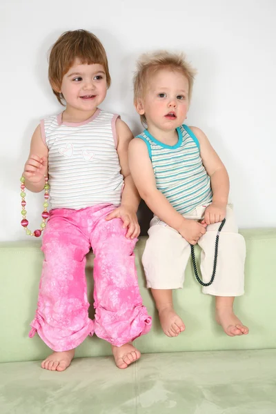 Két gyerek kanapé gyöngyökkel — Stock Fotó