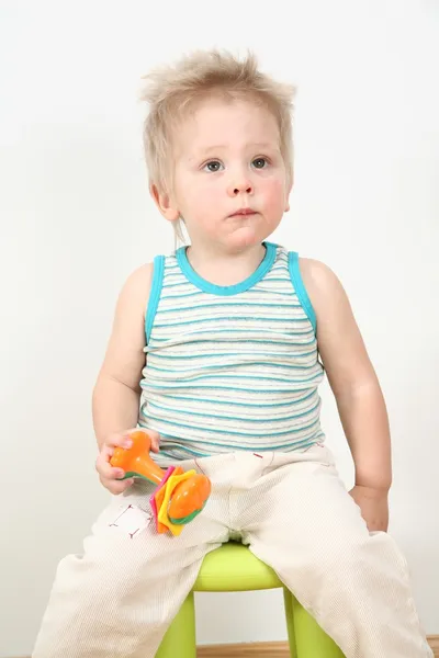 おもちゃで椅子の上の少年 — ストック写真