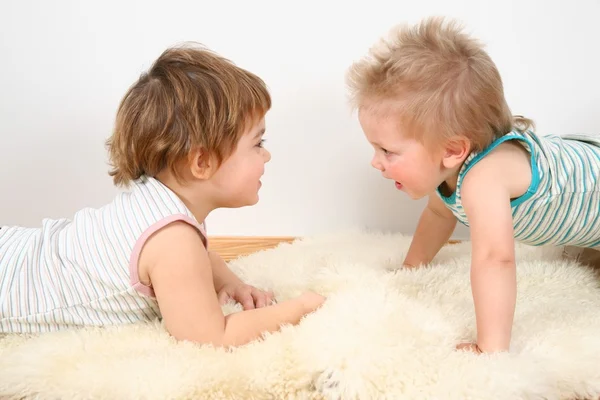 Двое детей на ковре из меха — стоковое фото