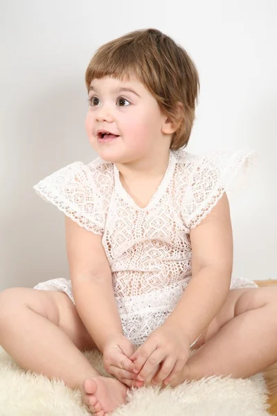 Bambino seduto su tappeto di pelliccia — Foto Stock