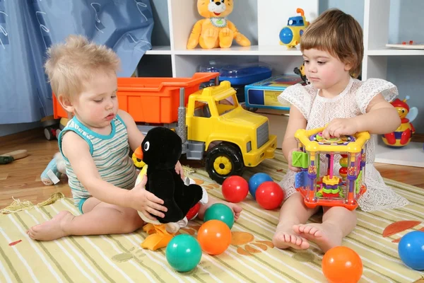 Двое детей в игровой комнате с игрушками — стоковое фото