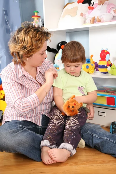 Мать с ребенком сидеть на полу в игровой комнате — стоковое фото