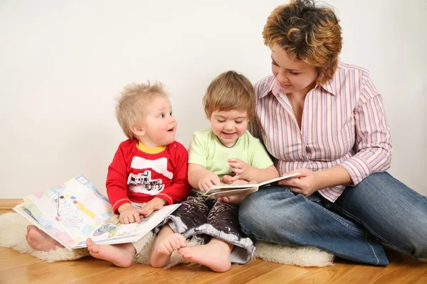 Niños buscando libros con madre —  Fotos de Stock