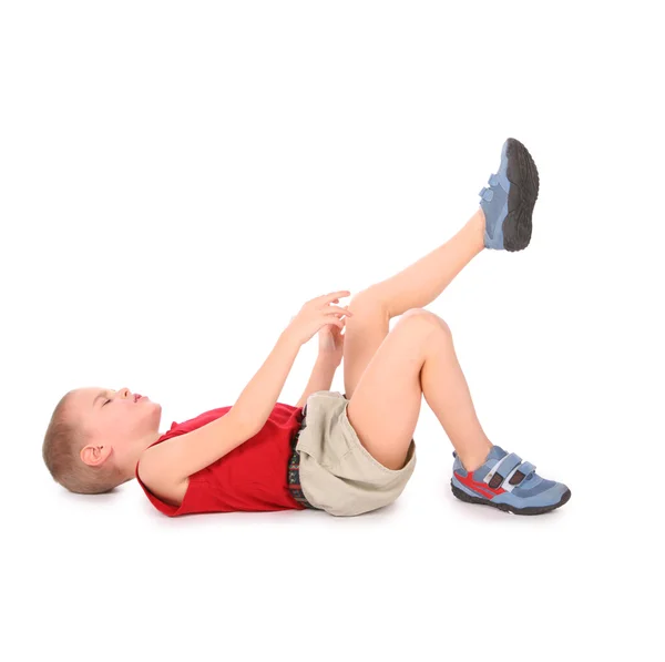Chlapec lež izolované na bílém. bolesti nohou — Stock fotografie