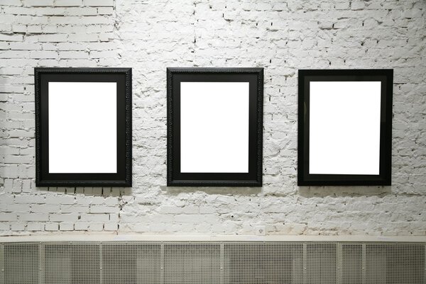 Black frames on white brick wall
