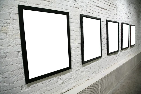Row of black frames on white brick wall — Stock Photo, Image