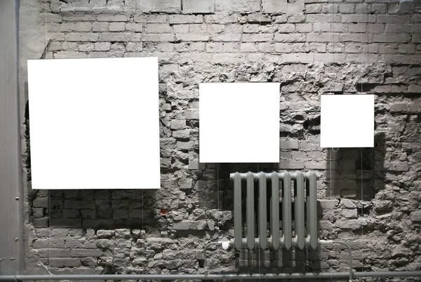 Trois cadres vierges sur mur de briques grises — Photo