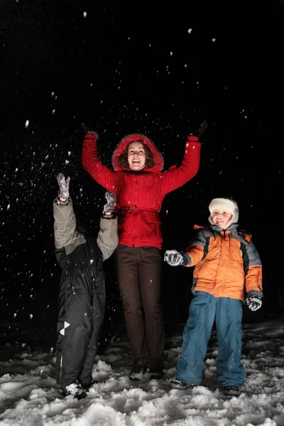 Enfants et mère jettent de la neige dans la nuit 3 — Photo