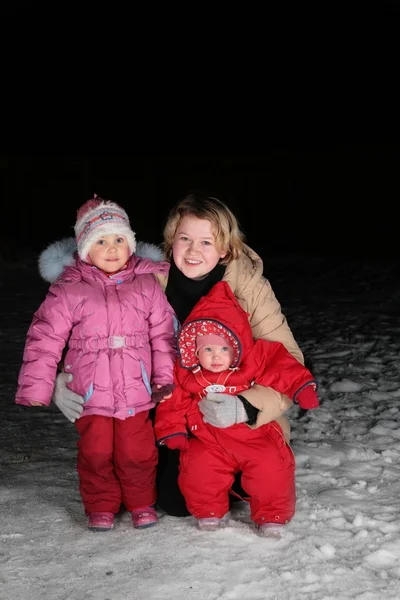 Mère avec des enfants sur la neige dans la nuit — Photo