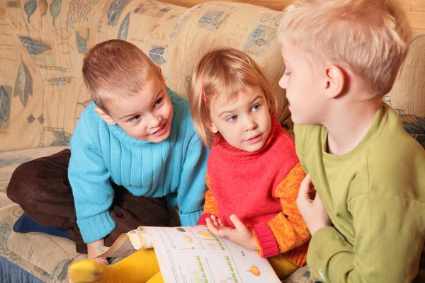 Dzieci, poczytać książkę na kanapie w pokoju drewniane 3 — Zdjęcie stockowe