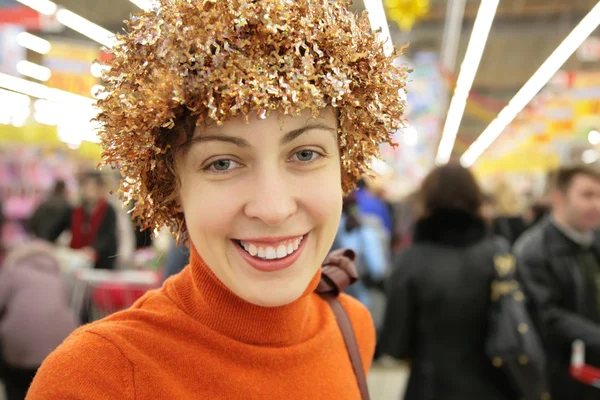Jeune femme avec tinsel lumineux en magasin — Photo