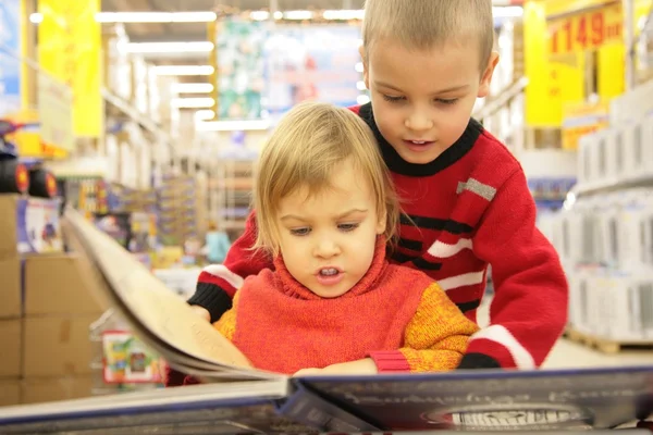 Двое детей ищут книгу в магазине — стоковое фото