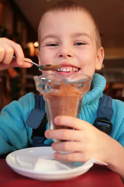 Мальчик ест шоколадный десерт — стоковое фото
