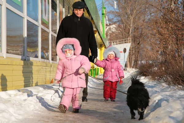Dziadek dziecko i pies spacer na ulicy w zimie — Zdjęcie stockowe