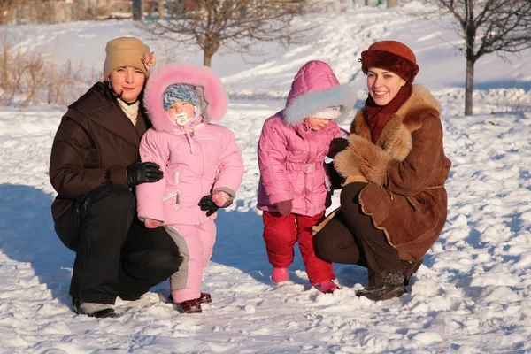 Две мамы с детьми на открытом воздухе зимой — стоковое фото