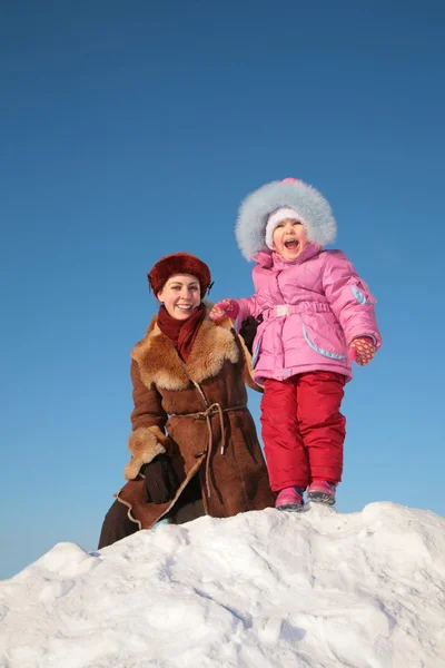 Mor med barn stå på snow hill — Stockfoto