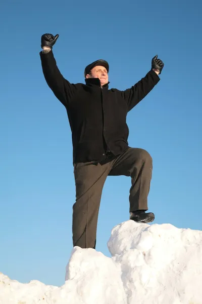 Пожилой человек на снежном холме с поднятой рукой — стоковое фото
