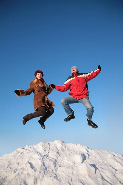 Couple jump on top of snow hill — Stock Photo, Image