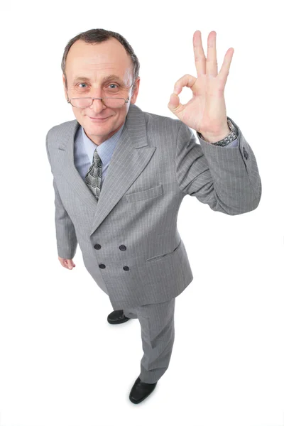 Man i grå kostym ger gest ok — Stockfoto