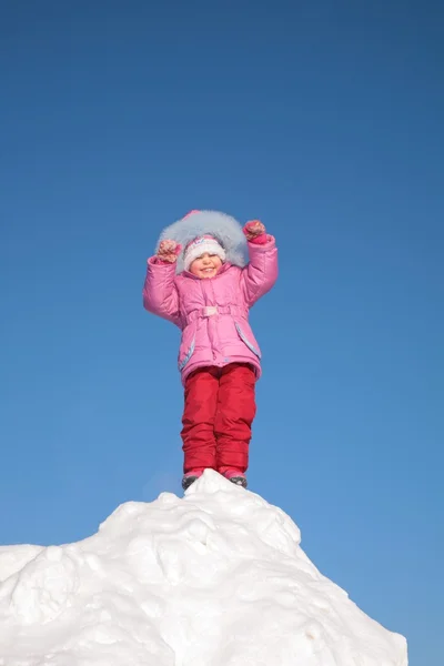 Niño está parado en la cima de la colina nevada — Foto de Stock