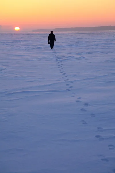 Ο άνθρωπος περνά μέσα από το χιονισμένο πεδίο — Φωτογραφία Αρχείου
