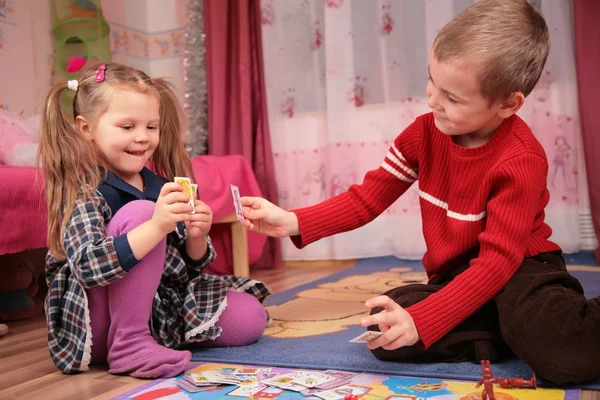 Двое детей играют в карты в игровой комнате — стоковое фото